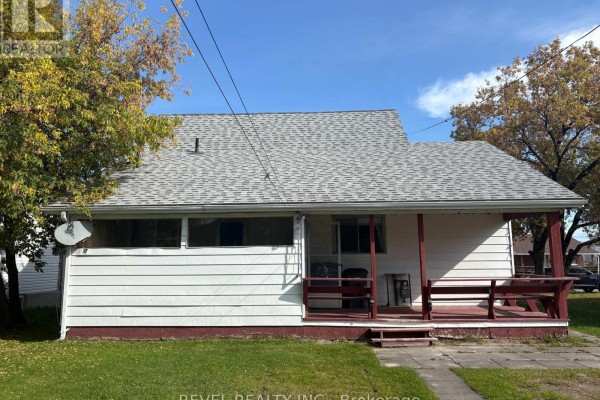 Rear exterior view of the house at 107 Fifteenth Avenue with white siding and a red-railed porch. - 107 Fifteenth Avenue, Cochrane