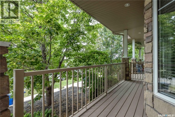 View from the covered porch overlooking trees and the street below. - 107 Galloway Road, Saskatoon