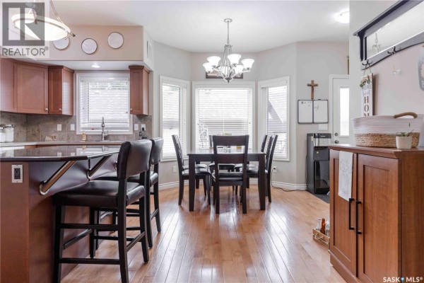 Dining area adjacent to the kitchen with a bay window and wooden table. - 107 Galloway Road, Saskatoon
