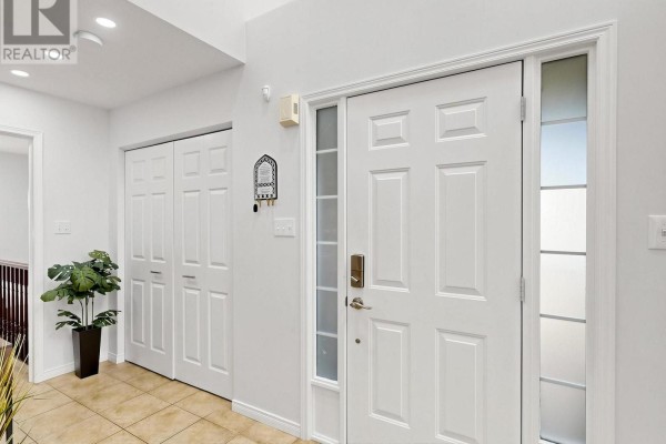 Interior foyer with a white front door, sidelights, key hook, and bi-fold closets on a tiled floor. - 107 Green Bank Drive, Cambridge