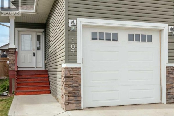 Close-up of the white garage door at 107 Henderson Crescent with stone accents on the lower portion. - 107 Henderson Crescent, Penhold