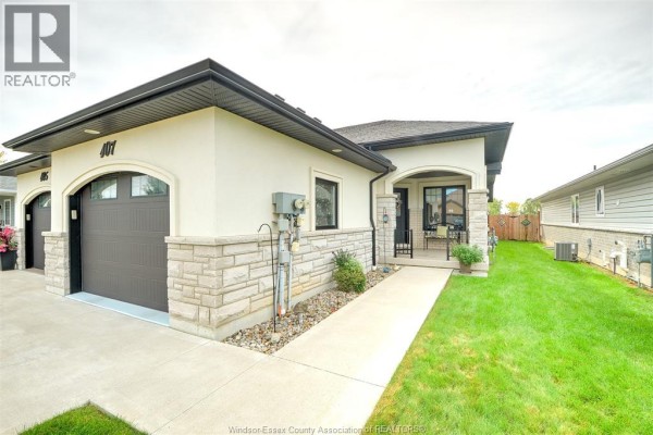Close-up exterior view of the house entrance and double garage doors with stone detailing. - 107 Meadowview, Amherstburg