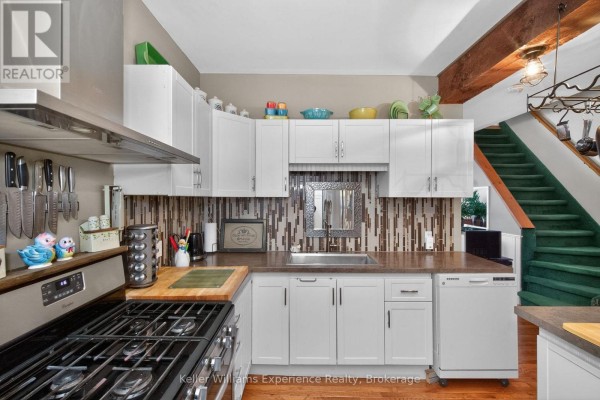 Bathroom with a soaking tub, toilet, vanity with dark wood cabinets, and large mirror. - 107 Pine Street, Tay