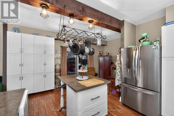 Bedroom with a twin bed, electric fireplace, dresser, and window with white curtains. - 107 Pine Street, Tay