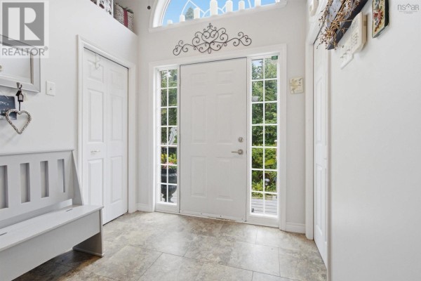 White front door with sidelights and a transom window, leading to a bright foyer. - 107 Waterstone Run, Lucasville