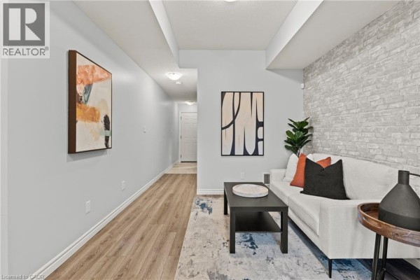 Living room with modern abstract art on light grey walls and hallway leading to doors. - 107 Westra Drive Unit# 59, Guelph