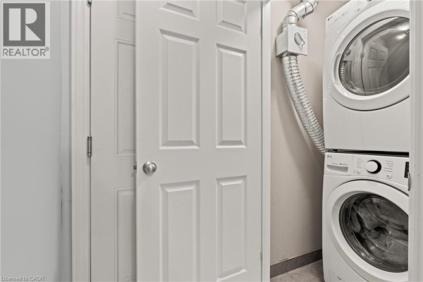 Stacked white LG washer and dryer next to white closet doors. - 107 Westra Drive Unit# 59, Guelph