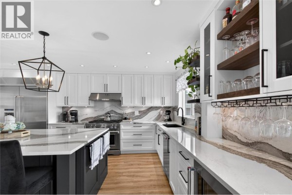 Kitchen featuring white cabinetry, quartz countertops, a wine fridge, and open shelving display. - 1070 Maccleave Avenue, Penticton