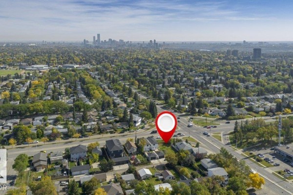 Distant aerial view showing the property's location within a dense suburban neighborhood with a city skyline. - 10712 149 St Nw, Edmonton