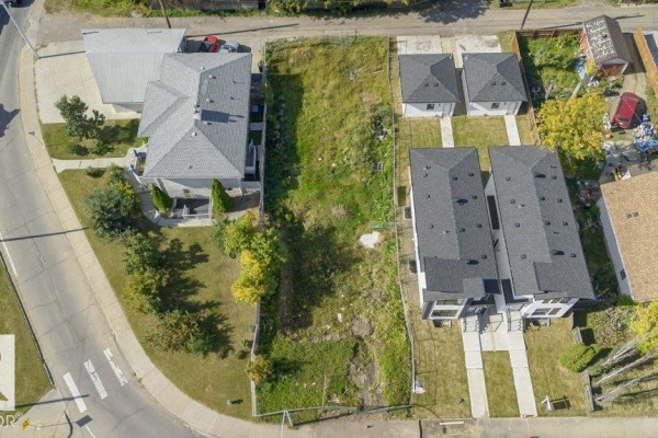Overhead drone shot of an empty rectangular lot with grass and dirt, bordered by houses and alleyways. - 10712 149 St Nw, Edmonton