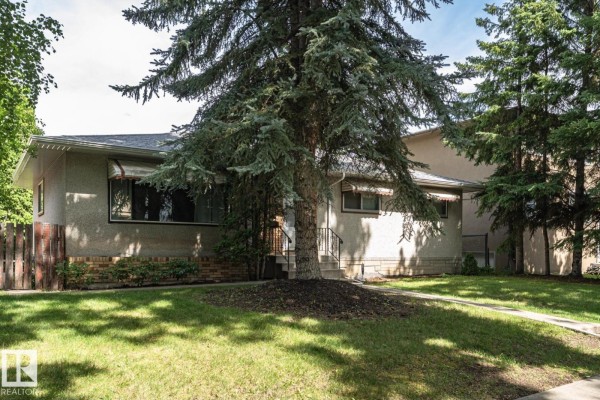 Side exterior view of the house showing a pathway and manicured lawn. - 10726 70 Av Nw, Edmonton