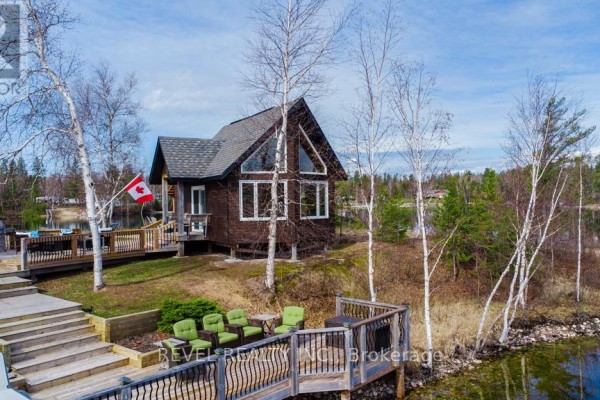 Aerial view of a waterfront property with multiple houses and a dock along the shoreline. - 1075 Cameron Avenue, Iroquois Falls