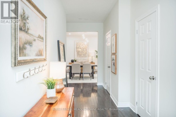 Hallway with dark hardwood floors and a view into a dining room. - 1079 Job Crescent, Milton