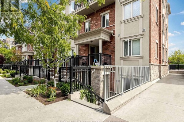 Front exterior of a brick and stucco townhouse complex with green trees. - 108 - 17 Coneflower Crescent, Toronto