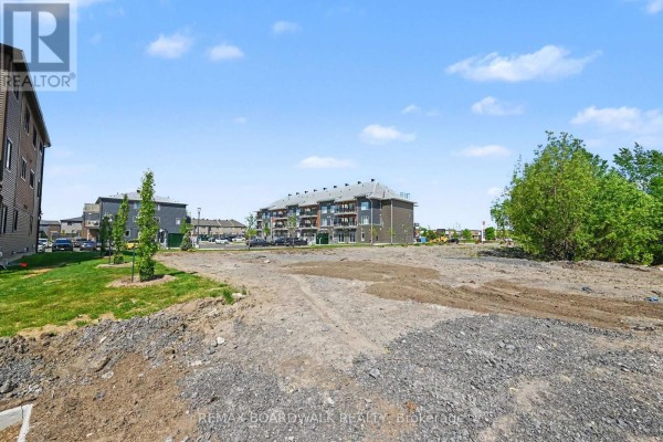 Dirt lot with gravel and mounds of earth next to a residential building. - 108 - 2370 Tenth Line Road, Ottawa