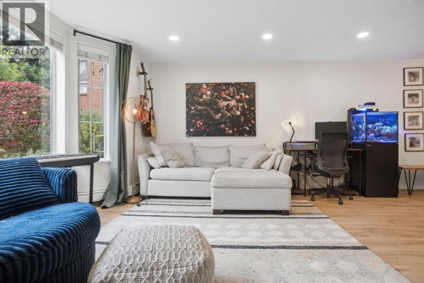 Living room with fireplace, sectional sofa, desk area with computer, and aquarium. - 108 1655 Augusta Avenue, Burnaby