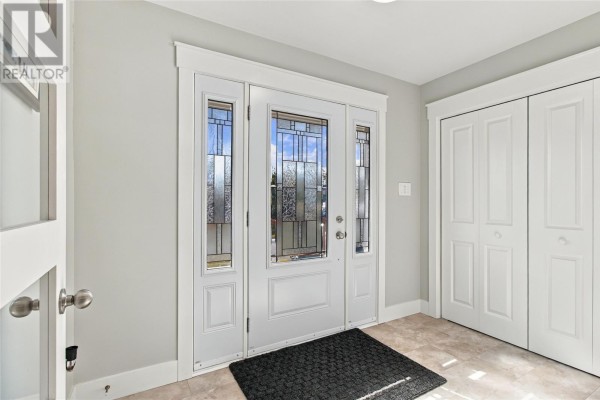 Interior entrance with a white door, stained glass sidelights, and light beige tiled floor. - 108 Country Drive, Torbay