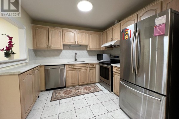 Kitchen with light wood cabinets, stainless steel appliances, and a dishwasher. - 108 Freshmeadow Drive, Toronto