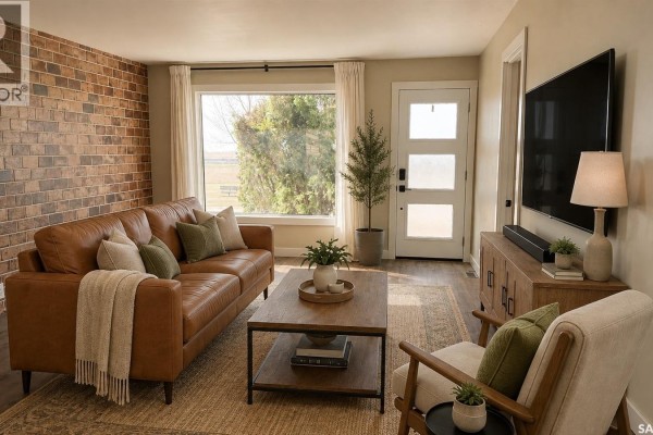 Interior view showing wood floors, electric fireplace, television, and doorways to other rooms. - 108 Front Street N, Pense