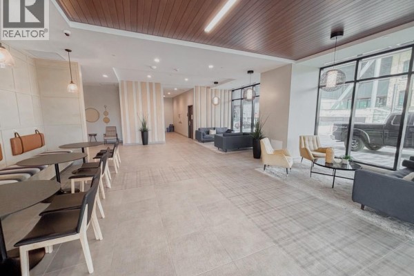 Building lobby lounge area with tables, chairs, sofas, and a recessed seating area. - 108 Garment Street Unit# 807, Kitchener