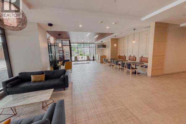 Spacious building lobby with a sofa, coffee table, and a long booth seating area. - 108 Garment Street Unit# 807, Kitchener