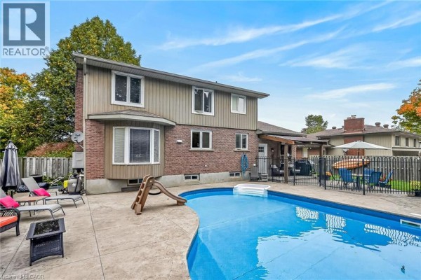 Backyard with an in-ground swimming pool, patio, and fencing. - 108 Temperance Street E, Waterford