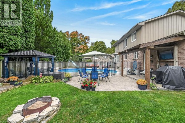 Backyard patio with outdoor dining set, covered gazebo, and fire pit. - 108 Temperance Street E, Waterford