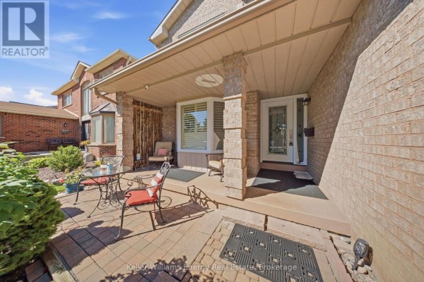 Covered front porch with seating area and brick patio with two chairs and a table. - 1083 Ridge Valley Drive, Oshawa