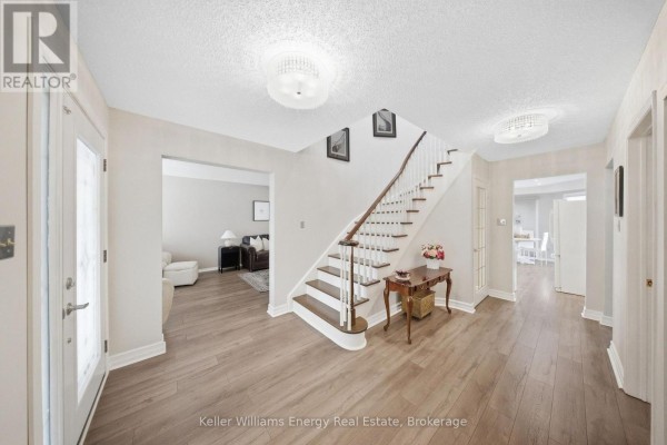 Spacious foyer with light wood flooring, a staircase, and doors leading to other rooms. - 1083 Ridge Valley Drive, Oshawa
