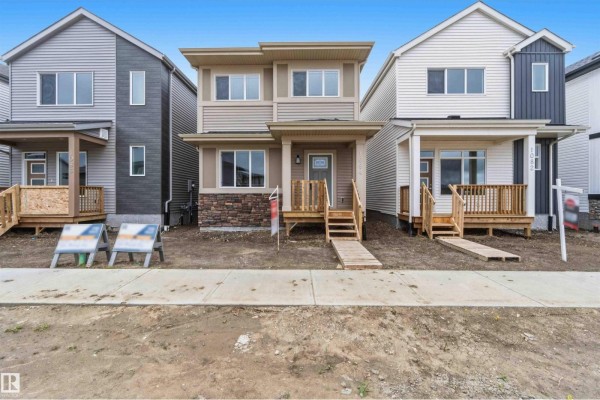 Front exterior of a townhouse at 1084 McLeod Av, Spruce Grove, with tan and stone siding. - 1084 Mcleod Av, Spruce Grove