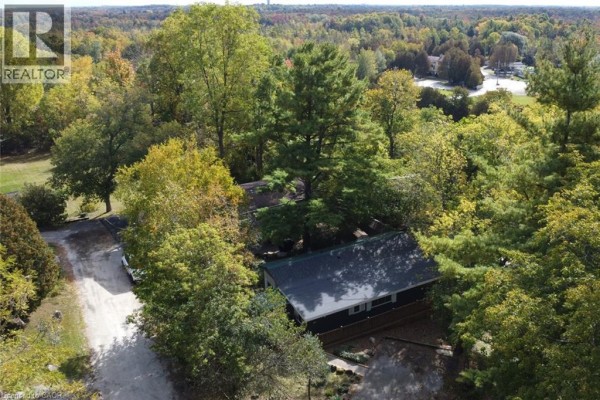 Aerial drone view of the mobile home surrounded by mature trees with autumn foliage. - 1085 W Concession 10 Concession W Unit# 99, Flamborough