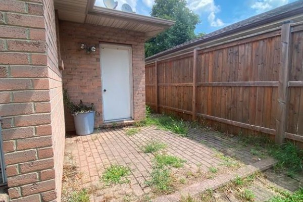 Small brick patio area next to the back door with a grey planter. - 1087 Brookview Crescent, Windsor