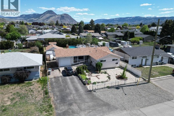 Aerial view of the rear of the house, showing a pool, patio, shed, and detached garage. - 1087 Laroque Street, Kamloops