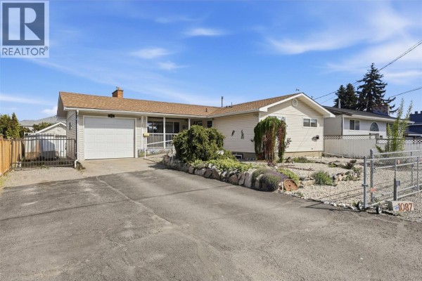 Overhead view of the backyard with an oval swimming pool, patio, hot tub, and detached garage. - 1087 Laroque Street, Kamloops