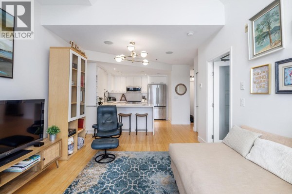 Open layout connecting living room to kitchen, with bar seating and modern appliances. - 1088 Sunset Drive Unit# 247, Kelowna