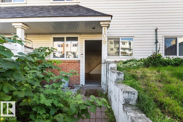 Front entrance of townhouse 108 with brick and vinyl siding. - #108a 14520 52 St Nw, Edmonton