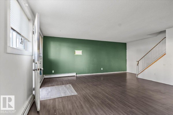 Living room with dark wood laminate flooring and white blinds on window. - #108a 14520 52 St Nw, Edmonton
