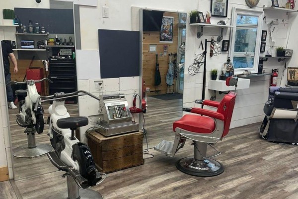 Interior view of a barber shop with a motorcycle, barber chairs, and vintage cash register. - 109 - 2067 Lake Shore Boulevard W, Toronto