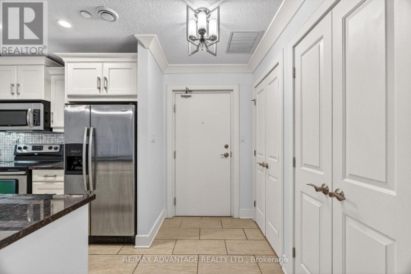 Primary bedroom with king bed, dresser, mirror, and accent chair. - 109 - 320 Sugarcreek Trail, London North