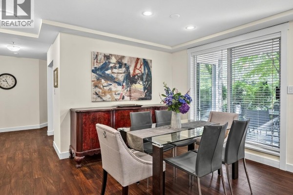 Dining area with buffet, glass table, chairs, and doors leading to a patio. - 109 1283 Parkgate Avenue, North Vancouver