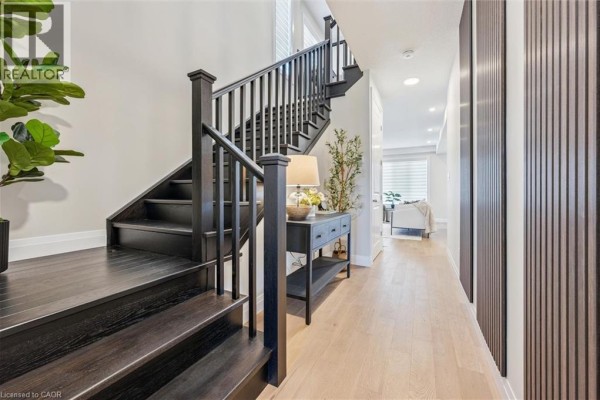 Modern kitchen with white cabinets, quartz countertops, stainless steel appliances, and island. - 109 Catherine Street, New Hamburg