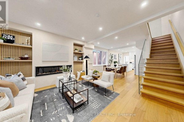 Spacious living area and kitchen with white cabinets and stainless steel appliances. - 109 Fermanagh Avenue, Toronto
