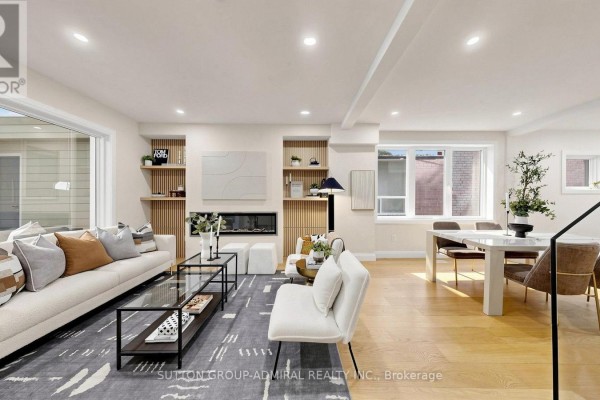 Living room feature wall with a modern electric fireplace and wood paneling. - 109 Fermanagh Avenue, Toronto