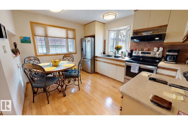 View of a kitchen featuring light wood floors, stainless steel appliances, and a breakfast nook. - 109 Galen Pl, Sherwood Park