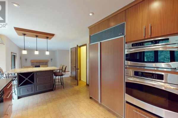 Kitchen with large island, granite countertops, ovens, and pendant lights - 109 Greenview Ln Sault Ste Marie