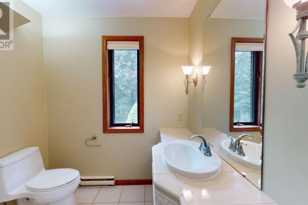 Bathroom with toilet, sink, mirror, and window - 109 Greenview Ln Sault Ste Marie