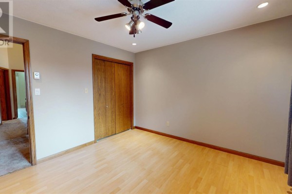 Bedroom with laminate floor, closet, ceiling fan, and grey curtains - 109 Greenview Ln Sault Ste Marie