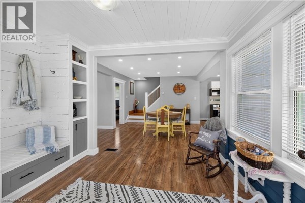 Interior view of a bright room with wood floors, white shiplap ceiling, and dining area. - 109 Hodgkins Avenue, Thorold