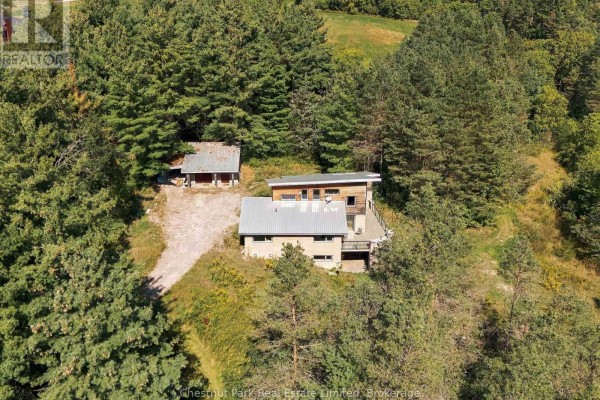 Top-down view of the house and detached structure on a wooded lot with a gravel driveway. - 109 Mount Pleasant Road, Cramahe