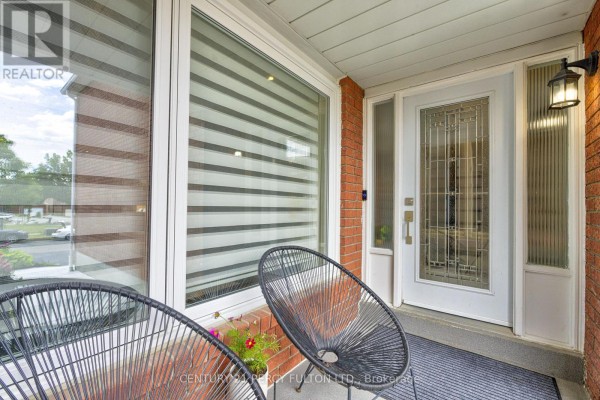 Close-up of the front entrance with a glass-paneled door and a window with blinds. - 109 Woodcroft Lane, Vaughan